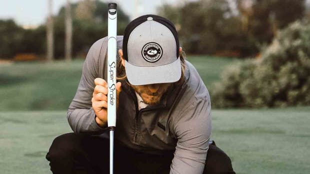 A player lines up a putt while holding a putter with a SuperStroke grip.